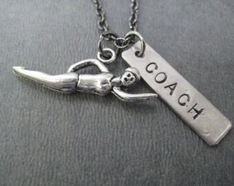 May include: Silver necklace with a swimmer charm and a tag that says "COACH".