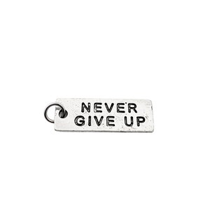 May include: Silver charm with a rectangular shape and a ring for attaching to a chain or bracelet. The charm has the words "NEVER GIVE UP" engraved on it.