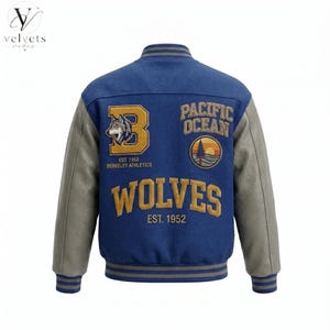 May include: A blue varsity jacket with grey sleeves and striped ribbed trim. The back features embroidered patches including a large letter B with a wolf head, the text Pacific Ocean, Berkeley Athletics, Wolves, and the year Est. 1952.
