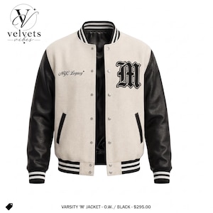Pode incluir: Uma jaqueta varsity com corpo na cor creme e mangas pretas, gola, punhos e bainha canelados em preto com listras brancas. A frente apresenta um patch com a letra M preta, o texto NYC Legacy e botões de pressão prateados no centro.