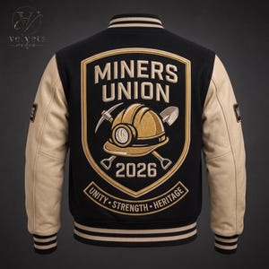 May include: A black varsity jacket with beige sleeves and striped ribbed trim. The back features a large embroidered shield patch with the text MINERS UNION 2026, a gold hard hat, a pickaxe, and a shovel, plus a banner reading UNITY STRENGTH HERITAGE.
