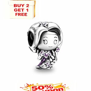 May include: A silver charm featuring a cartoon character with a large head and flowing hair. The charm is wearing a purple dress and has the word "Pandora" engraved on it. A gift box with a gold bow and the text "BUY 2 GET 1 FREE" is in the background.