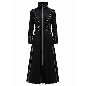 May include: A long black coat featuring a high collar with double buckles, a central full-length zipper, and multiple silver-toned zippers on the chest and lower panels. The garment includes adjustable buckle straps at the waist and cuffs.