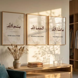 May include: Three framed art prints with Arabic calligraphy. The prints are in light wood frames and feature elegant script with English translations: "In the name of Allah", "All praise is due to Allah", and "What Allah has willed".