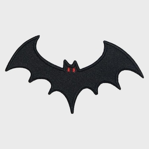 May include: A black bat-shaped patch with red eyes. The patch is made of a textured fabric and features a detailed embroidered design. The bat has pointed ears and a pointed tail. This patch is perfect for Halloween or gothic-themed projects.
