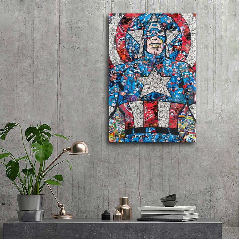May include: A framed Captain America artwork. The artwork features a collage of comic book images in red, white, and blue, forming the iconic superhero's likeness. The star-shaped shield and costume details are prominent. The artwork is mounted on a gray concrete wall.