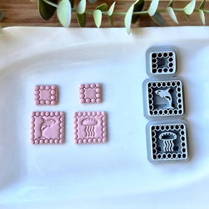 Może przedstawiać: Biały ceramiczny kubek z czarnym uchwytem i napisem "But First, Coffee" pogrubioną czcionką. Kubek jest umieszczony na rozmytym tle, sugerującym przytulne otoczenie.