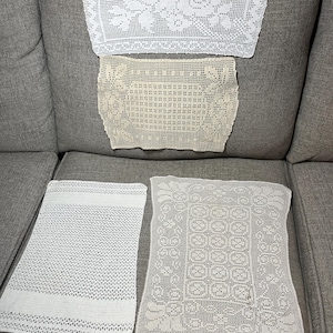 May include: Four rectangular crochet doilies arranged in a group. One is bright white with a floral pattern, one is cream with a geometric design, one is white with a textured grid pattern, and one is white with an intricate floral border design.
