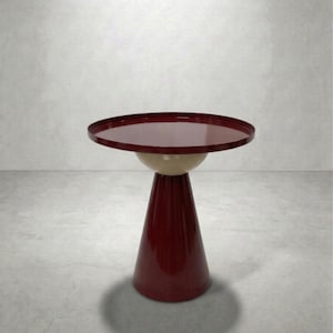 May include: A modern side table with a burgundy red conical base and a cream-colored sphere supporting a round, burgundy red tabletop. The table is a unique piece of furniture.