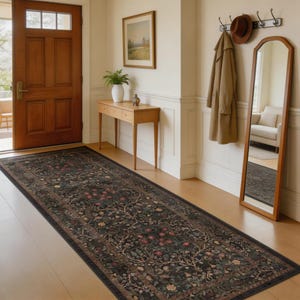 May include: A long, rectangular rug with a dark background and a floral pattern in shades of red, green, and cream. The rug is placed in a hallway with a wooden door, a mirror, and a coat rack.
