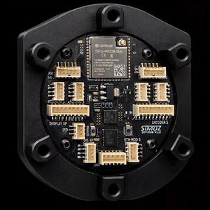 Puede incluir: Un concentrador de placa de circuito electrónico circular negro con un módulo ESP32-WROOM-32UE, múltiples puertos de conector blancos y texto impreso que incluye SIMUZ DIY-HUB V1.0, DISPLAY 8P, ENCODER 1 y BTN-MOD S, montado en un marco negro.
