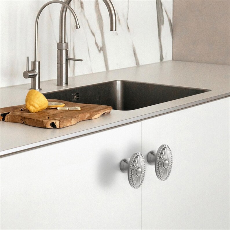 K&ouml;nnte beinhalten: Eine wei&szlig;e Keramik-Tasse mit schwarzem Henkel und dem Text "But First, Coffee" in handschriftlichem Stil. Die Tasse steht auf einer wei&szlig;en Oberfl&auml;che. Die Tasse ist 10 cm hoch.