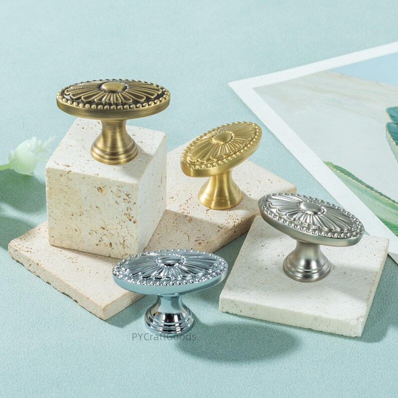 K&ouml;nnte beinhalten: Drei cremefarbene Keramikbecher mit gesprenkelter Glasur. Jeder Becher zeigt ein handgemaltes Blumenmuster in Blau-, Gr&uuml;n- und Gelbt&ouml;nen. Die Becher haben eine einfache, abgerundete Form und einen Henkel.