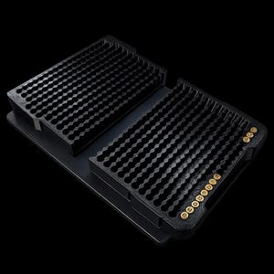 May include: A black rectangular tray with a grid of small circular indentations for organizing items. The tray features two raised sections with rows of slots, and a small group of gold-colored circular tokens are placed in the right section.