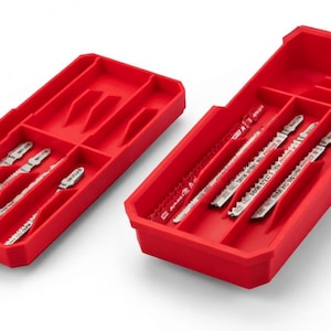May include: Two red plastic storage containers with multiple compartments, each holding silver saw blades. The blades are arranged neatly within the compartments. The containers are on a white surface.