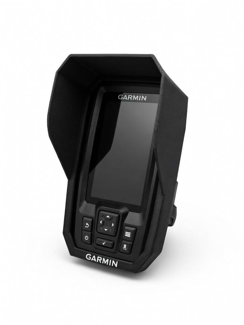 Puede incluir: Un buscador de peces Garmin negro con una cubierta protectora. El dispositivo tiene una pantalla, botones de control y el logotipo de Garmin. La unidad est&aacute; dise&ntilde;ada para uso marino y est&aacute; montada sobre un fondo blanco.