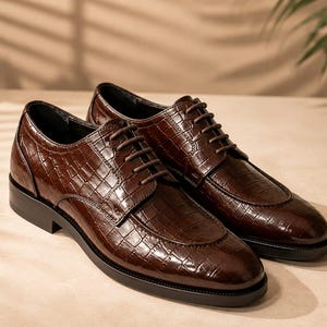 May include: A pair of dark brown dress shoes featuring a glossy crocodile-embossed texture, a rounded toe, and matching dark brown laces. The shoes have a low black heel and a structured silhouette with visible stitching along the vamp and sides.