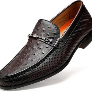 Pu&ograve; includere: Mocassino in pelle marrone con motivo strutturato e puntinato e design traforato. La scarpa presenta una fibbia color argento e una punta affusolata ed elegante. La suola &egrave; nera e la scarpa ha uno stile classico ed elegante.