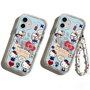 May include: Two clear phone cases with a light blue background featuring Hello Kitty illustrations, red bows, and travel-themed icons. The cases have a clear border and a beaded wrist strap. The text "Hello Kitty" is visible.