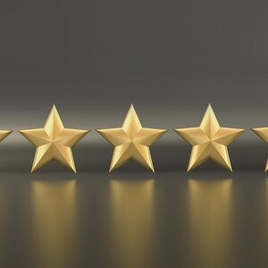 May include: Five gold stars arranged in a row, each with five points. The stars are evenly spaced and cast a reflection on the dark, glossy surface below. The background is a gradient of dark gray.