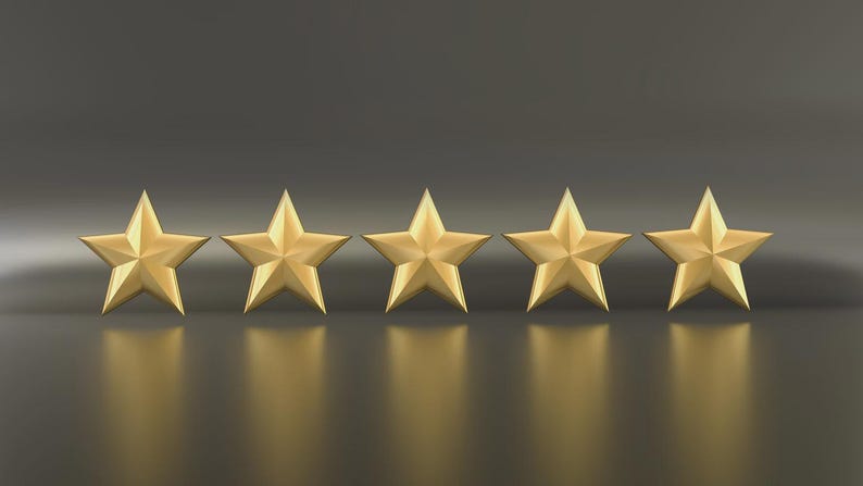 May include: Five gold stars arranged in a row, each with five points. The stars are evenly spaced and cast a reflection on the dark, glossy surface below. The background is a gradient of dark gray.