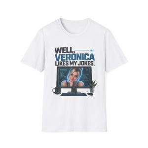 Könnte beinhalten: Ein weißes Kurzarm-T-Shirt mit einer Grafik eines Computermonitors, der eine Person namens Veronica zeigt. Der Text darüber lautet WELL, VERONICA LIKES MY JOKES. Eine schwarze Tasse, eine Tastatur, eine Maus und eine kleine Topfpflanze sind abgebildet.