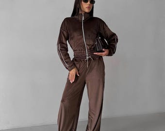 Tuta sportiva da donna in velluto, composta da giacca corta con zip e pantaloni a gamba larga, con finiture a righe.
