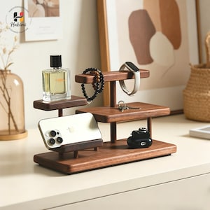 May include: A set of three ceramic mugs with a speckled, matte finish. The mugs are in shades of cream, light gray, and dark gray. Each mug has a simple, minimalist design and a rounded handle.