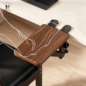 May include: A wooden desk armrest with a dark brown finish, attached to a black metal frame. The armrest is clamped to a white desk. The image shows a black chair with a black leather seat. The armrest is designed to provide support and comfort.