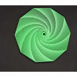 May include: A bright green, multi-layered coaster featuring a geometric, spiraling pattern that radiates from a central circular hole. The object is constructed from thin, interconnected lines forming a decagon shape with a textured, layered appearance.