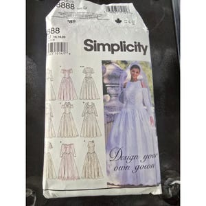 May include: A Simplicity sewing pattern packet featuring a woman in a white wedding gown with a veil. The packet includes illustrations of various dress designs. Text on the packet reads "Design your own gown."
