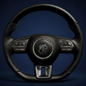 Könnte beinhalten: Ein schwarzes Lederlenkrad mit perforiertem Griff und silbernen Akzenten. In der Mitte befindet sich das MG-Logo. Das Lenkrad verfügt über integrierte Bedienelemente und ein sportliches Design, geeignet für Automobilenthusiasten.