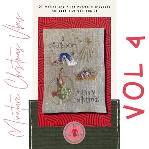 May include: A beige linen fabric with a cross-stitch design of a nativity scene. The design includes a star, a crown, a stocking, and the text "a child is born" and "merry christmas". The fabric is framed by a red and white patterned border.