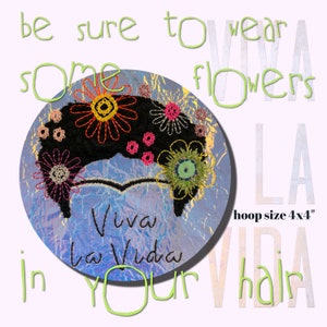 May include: Embroidered hoop art featuring a black silhouette of a woman with colorful flowers in her hair. The text "Viva la Vida" is embroidered in blue on a blue and white background. The hoop is 4 inches by 4 inches.