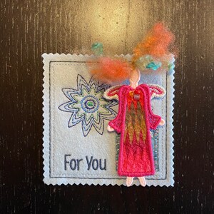 Puede incluir: Una tarjeta de fieltro hecha a mano con una flor bordada y una figura de &aacute;ngel de fieltro. La tarjeta tiene el texto "Para Ti" bordado.