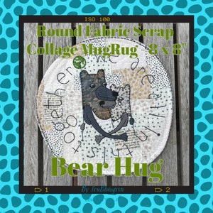 May include: Round fabric scrap collage mug rug featuring a design of two bears hugging. The rug is 8 inches by 8 inches and is made from a variety of fabrics. The text "Bear Hug" is written in green letters below the bears.