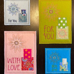 Puede incluir: Cuatro tarjetas de fieltro hechas a mano con dise&ntilde;os de flores cosidos y recortes de tela. Las tarjetas dicen "Para ti", "Para ti", "Con amor" y "Con amor".