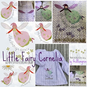 May include: A purple fabric dress with a white floral pattern and a hand-stitched embroidered fairy design. The design includes a fairy with wings and the text "She brings peace". The dress is labelled "Little Fairy Cornelia by fruBlomgren".