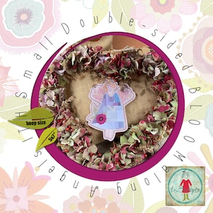 Peut inclure: Un motif de broderie double face représentant un ange fantaisiste avec une couronne de fleurs. Le motif est destiné à un cerceau de 5" et fait partie d'une collection appelée "Small Hoop Angels" par "fruit & green".