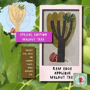May include: A raw edge applique walnut tree design with a squirrel at the base of the tree. The design is on a light brown linen fabric and is framed in a pink frame. The text "SPECIAL EDITION WALNUT TREE" is in a pink banner above the design. The text "RAW EDGE APPLIQUE WALNUT TREE" is below the design. The text "PERPECT XXL MOTIF FOR GARDEN FLAGS. WALL HANGERS ETC." is in a brown rectangle to the left of the design. The text "frutgren" is in a circle below the design.