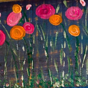 May include: A vibrant painting of a flower garden. The artwork features pink and orange flowers with green stems and leaves against a dark blue background. The brushstrokes are visible, giving the painting a textured appearance.