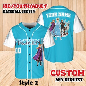 Może przedstawiać: Jasnoniebieska koszulka baseballowa z białymi rękawami. Z przodu napis "FROZEN" i numer "00". Z tyłu grafika postaci z filmu "Kraina Lodu" oraz napis "YOUR NAME". Koszulka oznaczona jako "Style 2".
