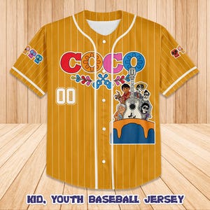 Peut inclure: Maillot de baseball jaune moutarde &agrave; fines rayures blanches, avec le mot "COCO" en rouge, rose et bleu, et un graphisme de personnages avec une guitare. Le maillot porte le num&eacute;ro "00" et le texte "KID, YOUTH BASEBALL JERSEY".