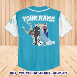 Puede incluir: Una camiseta de b&eacute;isbol azul claro con mangas y cuello blancos. La parte trasera presenta un gr&aacute;fico de personajes de dibujos animados y el texto "YOUR NAME". El texto "KID, YOUTH BASEBALL JERSEY" est&aacute; en la parte inferior.