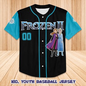 Może przedstawiać: Czarna koszulka baseballowa z turkusowymi rękawami i wykończeniami. Koszulka zawiera napis "FROZEN II" i numer "00" w kolorze turkusowym. Z przodu znajdują się zdjęcia Anny i Elsy. Tekst "KID, YOUTH BASEBALL JERSEY" znajduje się na dole.