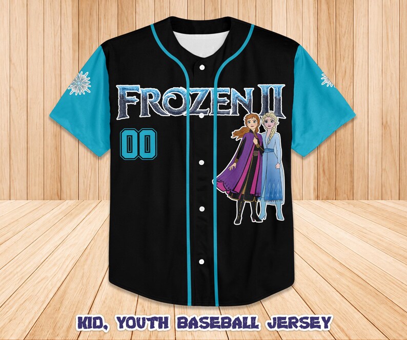 Może przedstawiać: Czarna koszulka baseballowa z turkusowymi rękawami i wykończeniami. Koszulka zawiera napis "FROZEN II" i numer "00" w kolorze turkusowym. Z przodu znajdują się zdjęcia Anny i Elsy. Tekst "KID, YOUTH BASEBALL JERSEY" znajduje się na dole.