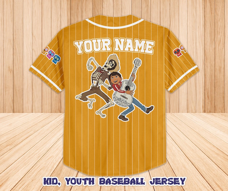 Peut inclure: Maillot de baseball jaune moutarde pour jeunes avec des fines rayures blanches, un col et des bordures de manches blancs. Comporte un graphisme d'un squelette et d'un gar&ccedil;on jouant de la guitare. Le texte "YOUR NAME" est au-dessus du graphisme.