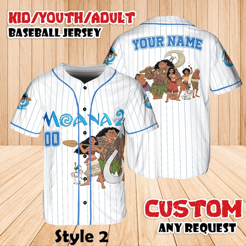 May include: White baseball jersey with blue pinstripes and accents. Features the text "MOANA 2" and "00" on the front, and a graphic of characters from the movie Moana. The back has the text "YOUR NAME" and a group of characters. The jersey is labeled "Style 2".