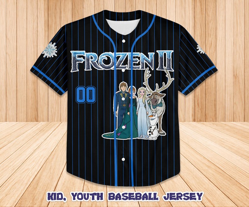 Puede incluir: Camiseta de b&eacute;isbol negra con finas rayas y detalles azules. La camiseta presenta el texto "FROZEN II" y un gr&aacute;fico de personajes de la pel&iacute;cula. El n&uacute;mero "00" est&aacute; en la parte delantera. El texto "KID, YOUTH BASEBALL JERSEY" est&aacute; en la parte inferior.