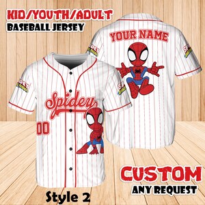 May include: White baseball jersey with red pinstripes and a cartoon Spider-Man graphic. The jersey has the word "Spidey" in red script on the front, with the number "00" below. The text "KID/YOUTH/ADULT BASEBALL JERSEY" is at the top.